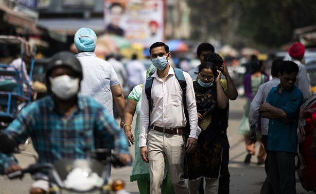 view of a street with people wearing masks post-covid